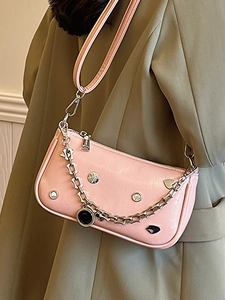Fashionable pale pink underarm bag with silver chain and decorative studs for women