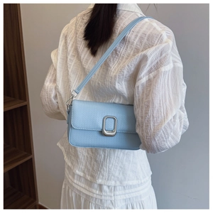 Close-up of light blue crossbody bag with lychee grain texture and silver metal buckle