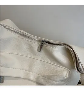 Detail shot of smooth silver metal zipper on white litchi pattern leather tote bag
