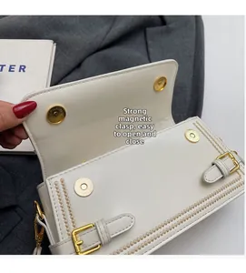 Close-up of white leather handbag featuring a strong magnetic buckle for easy opening
