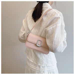 Pink pebbled leather shoulder bag with silver metal buckle shown from a back-cross perspective