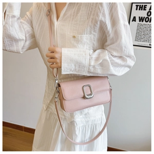 Detail of pink lychee leather crossbody bag with silver rectangular twist lock closure
