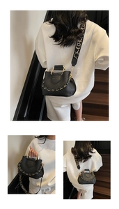 Detail of black lychee leather bucket bag with gold chain and patterned wide strap