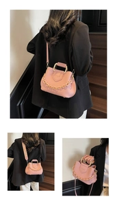 Detail of pink lychee leather handbag featuring a metal handle and gold chain strap