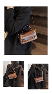 Detail of vintage brown leather bag with white contrast stitching and metallic buckle