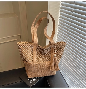 Détail du sac cabas tissé avec texture ajourée, motifs en V et pendentif à pompon décoratif