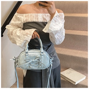 Close-up of light blue Boston bag featuring double bows and stylish drawstring details