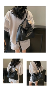 Detail of black PU leather tote bag featuring silver zipper and cute teddy bear charm