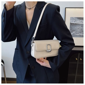 Detailed view of cream textured leather shoulder bag with rectangular silver metal lock buckle