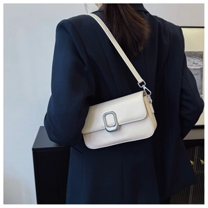 Detail of cream white crossbody bag with woven texture and silver buckle on model