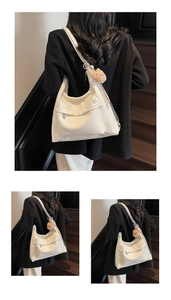 Detail view of large cream hobo tote bag featuring side zipper pocket and silver chain strap