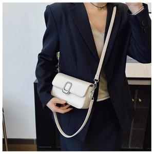 Close-up of cream textured leather crossbody bag with elegant silver buckle detail