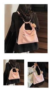 Detail view of pink leather backpack with textured finish and brown teddy bear charm