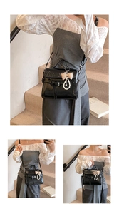 Close-up of black glossy mini square bag with elegant pearl bow charm and strap