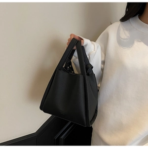 Detailed close-up of black lychee grain bucket bag with FASHION BAGS embossed lettering