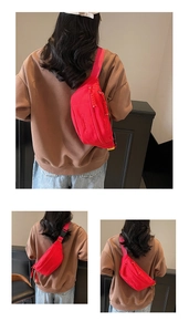 Detail of red nylon waist bag featuring woven zipper pull and adjustable black buckle