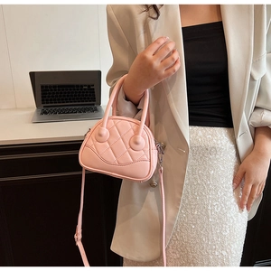Close-up of pink quilted crossbody bag showing rhombic texture and silver metal details