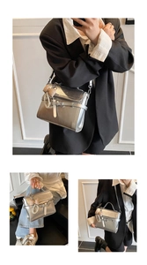 Detail of silver metallic crossbody bag with buckle strap, pearl charm and bow accessory