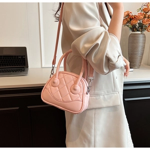 Close-up of pink quilted mini Boston bag with silver hardware and adjustable shoulder strap