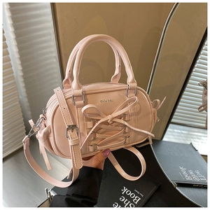 Detailed view of pink glossy Boston bag featuring ribbon bow and silver metal logo