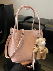 Minimalist light pink bucket bag in lychee texture leather with a cute bear pendant