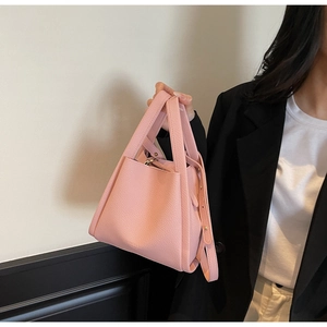 Detailed view of pink lychee pattern bucket bag with gold-tone hardware and straps