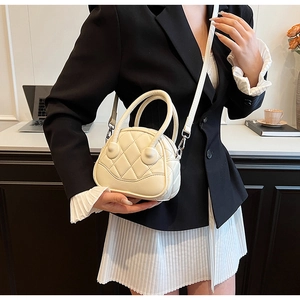 Close-up of beige quilted leather crossbody bag styled with professional outfit