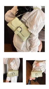 Three-way view of a light green rectangular bag with a large silver round metal buckle detail