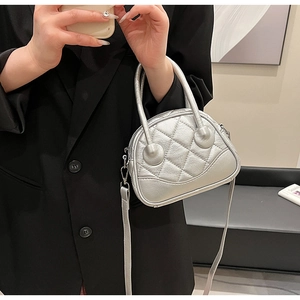 Detail view of silver quilted Boston bag with metallic finish and round top handles