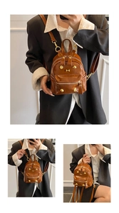 Detailed close-up showing the golden hardware and dark brown oil wax leather of the mini backpack