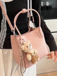 Pink lychee grain bucket bag with plush bear charm and detachable shoulder strap for women
