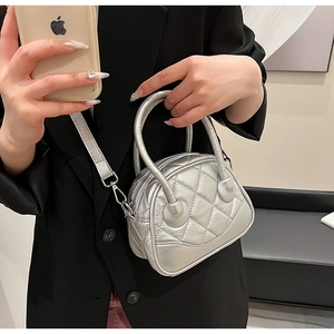 Chic silver quilted mini Boston bag with shiny metallic finish and crossbody strap detail