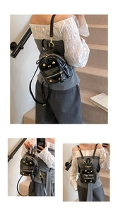 Detail of a mini black faux leather backpack with gold bone studs and punk style zippers
