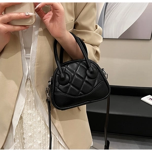 Close-up of black quilted leather boston bag with elegant diamond stitching and sleek handle