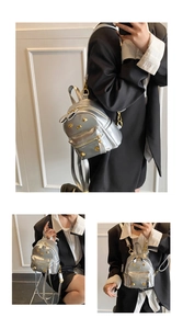 Silver mini backpack featuring golden bow accent and rivet details for a stylish look