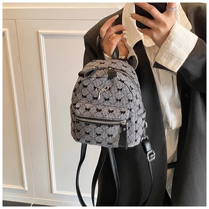 Mini backpack featuring classic black and white gingham pattern with cute bow charm detail
