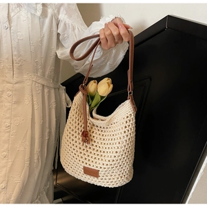 Détail du sac en maille crème tissé main avec bandoulière en cuir brun et décor floral