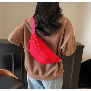 Detail view of the red nylon cross-body chest bag with brand logo and orange MULA side label