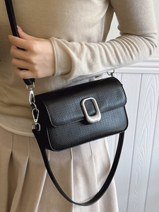 Minimalist black rectangle crossbody bag with silver oval metal buckle and leather texture