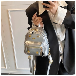 Detail view of mini silver PU leather backpack with gold puppy and bone studs