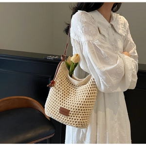 Gros plan du sac en crochet avec bandoulière en cuir marron et perle d'ambre décorative