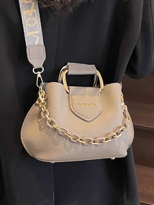 Beige lychee pattern bucket bag with gold ring handle and wide patterned shoulder strap