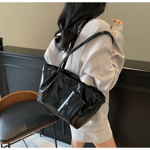 Vue détaillée du sac cabas en cuir noir ciré avec petit porte-monnaie assorti sur le côté