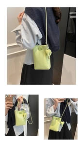 Detail view of lime green crossbody phone bag with pebble leather and m logo
