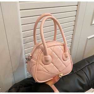 Close-up of pink quilted shell bag with silver D-rings and dual top handles