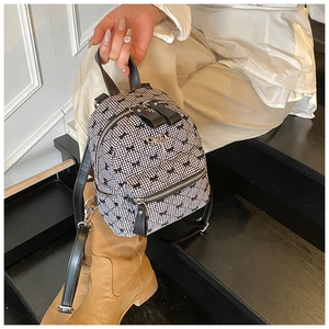 Detail of mini black and white plaid backpack with bow prints and golden bow buckle