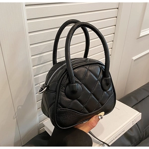 Close-up of black quilted Boston bag with glossy finish and silver metal hardware details