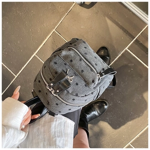Detail view of grey polka dot mini backpack with chevron fabric and leather straps