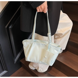Détail du sac cabas bleu clair en cuir ciré avec bandoulière spirale et plis chic