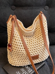Sac seau chic en maille beige avec bandoulières en cuir marron et breloque